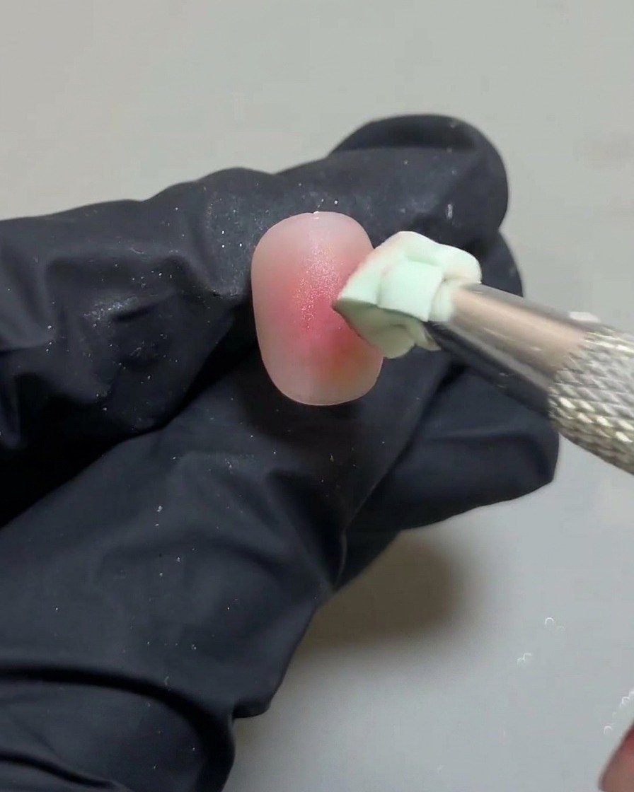 Nahaufnahme des Schwämmchens, das die Ränder des Blush-Designs perfektioniert.