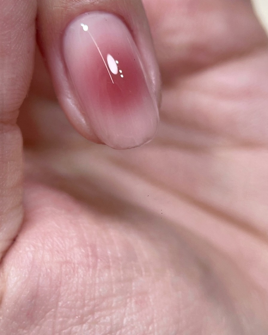 Nahaufnahme eines Fingers mit einem roséfarbenen Blush-Zentrum in einer UV-Nagellampe zum Aushärten.