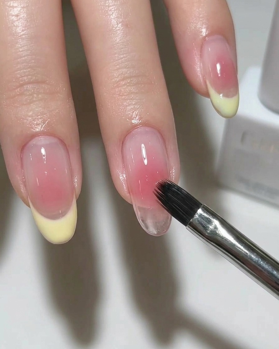 Ein Pinsel trägt einen schimmernden, silbernen Magnetlack auf die Nagelbasis auf.