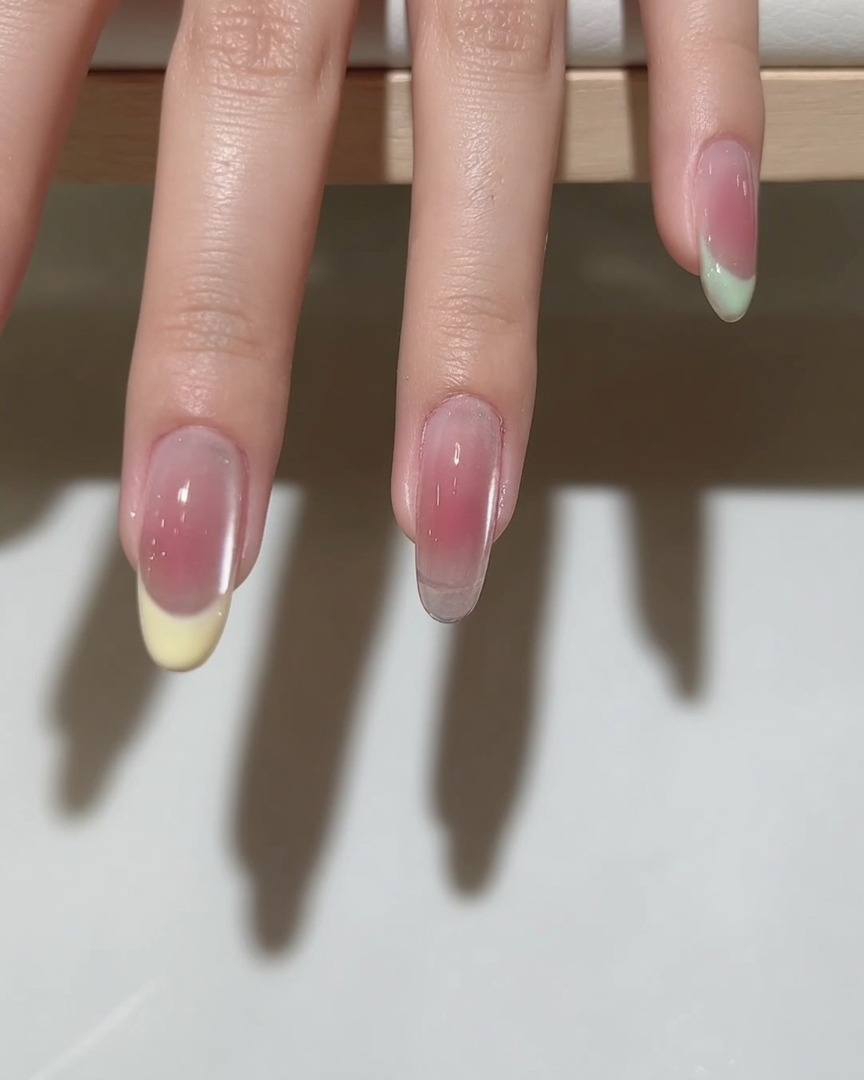 Ein feiner Liner-Pinsel zieht eine präzise Smile-Line auf dem Nagel, um das French-Tip-Design vorzubereiten.