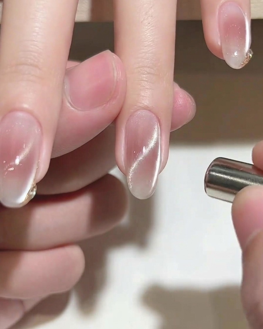 Ein feiner Liner-Pinsel fügt eine zarte Goldverzierung zur Nagelspitze hinzu.