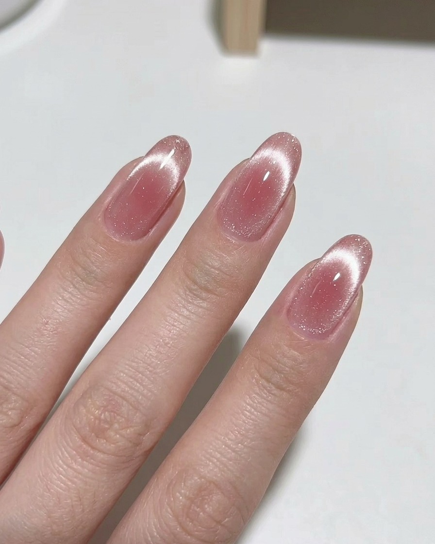 Ein Magnet-Tool wird nahe an den Fingernagel gehalten, um die Schimmer-Pigmente zu bewegen.