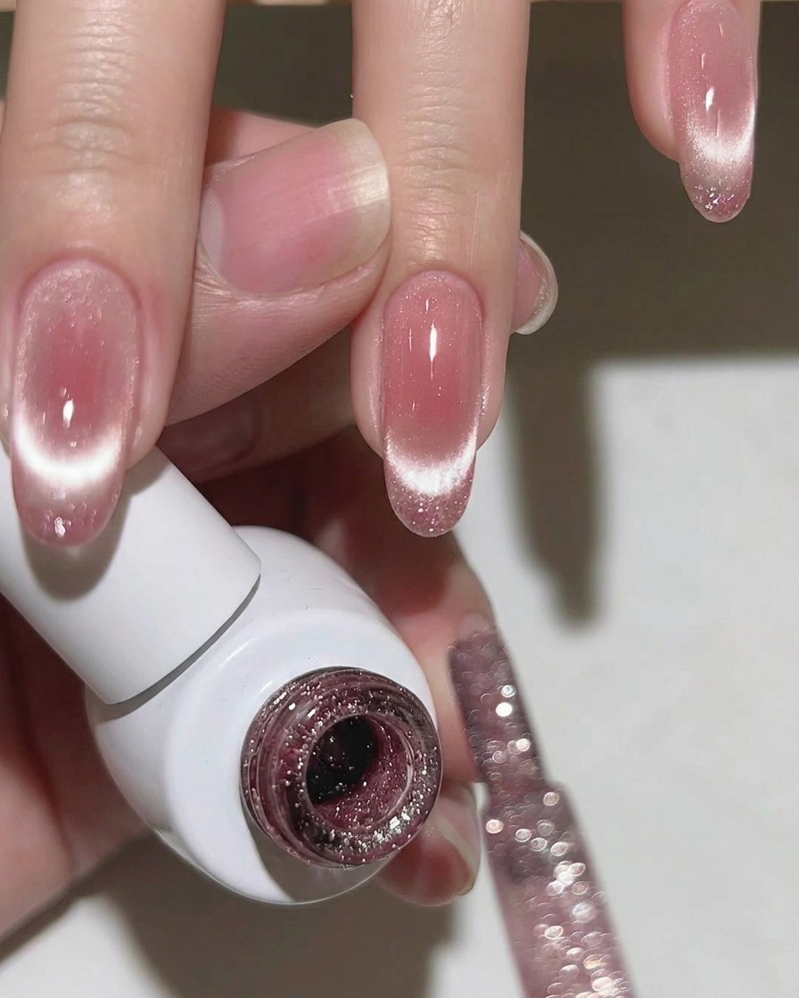 Nahaufnahme eines Fingernagels mit einer strahlenden, konzentrierten Cat-Eye-Linie auf der Spitze.