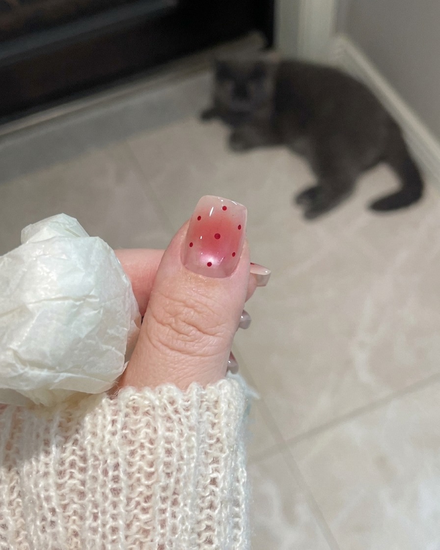 Nahaufnahme einer Hand mit mattierten Nägeln unter dem UV-Licht einer Nagellampe.