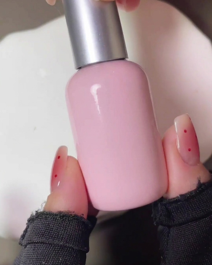 Die Nägel härten nach dem ersten Auftragen des roten Blush-Pigments unter einer UV-Lampe aus.