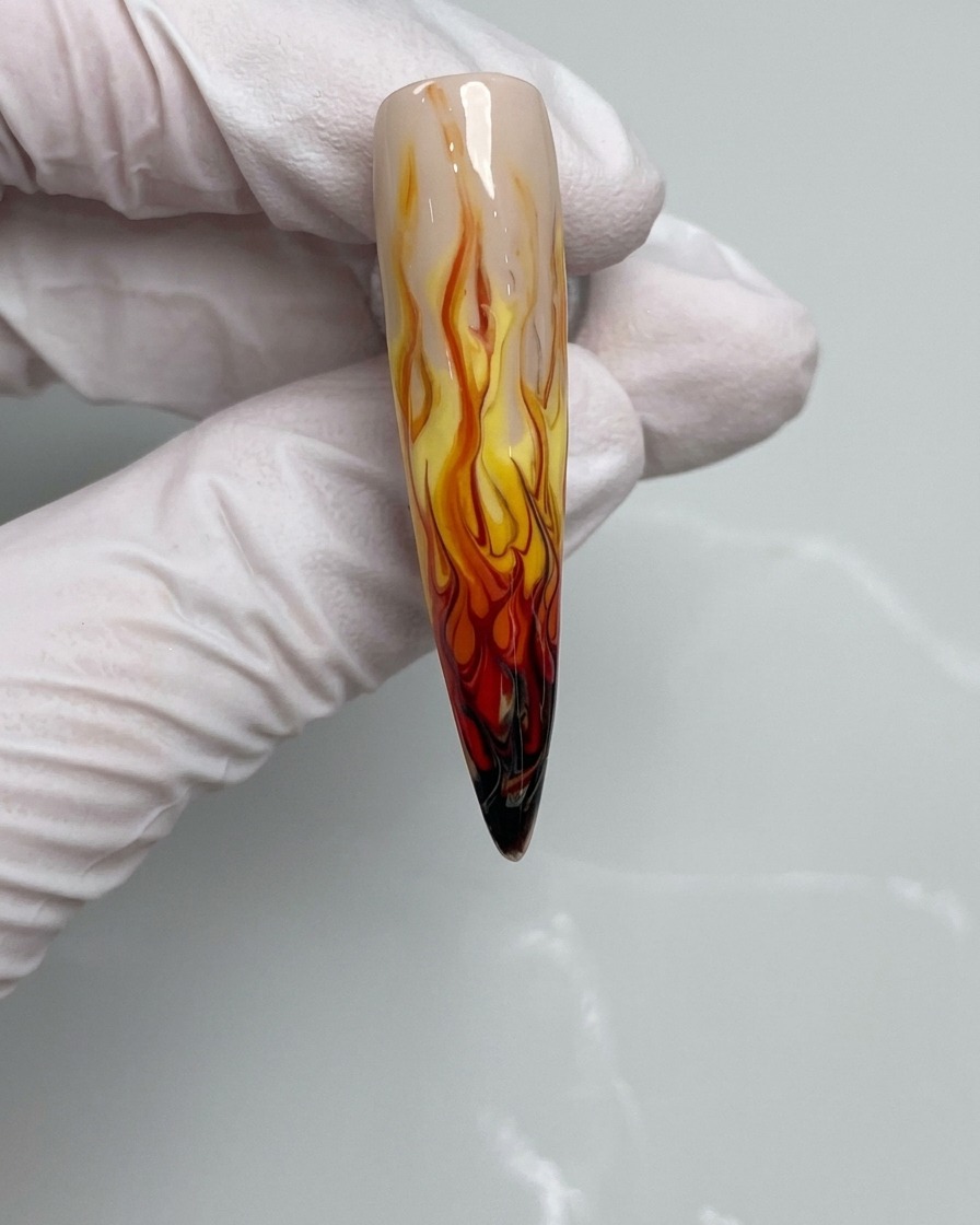 Ein Nagelpinsel, der schwarzes Farbgel auf die Nagelspitze aufträgt.