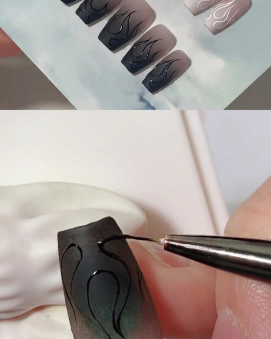 Nahaufnahme eines Liner-Pinsels, der schwarze Gelschichten hinzufügt, um die Flammenkonturen auf einem matten Nagel zu verdicken.