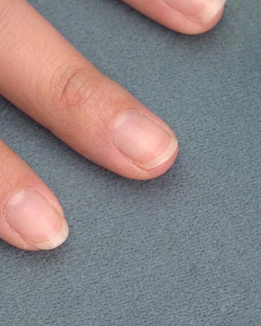 Ein weicher Pinsel entfernt lose Metallic-Partikel vom Nagel.