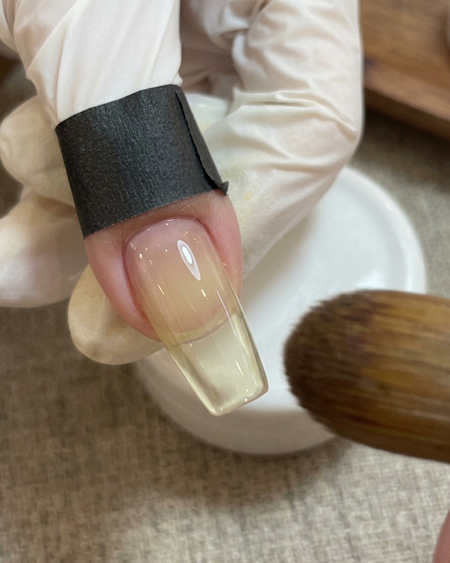 Ein Nagelmagnet wird über dem rosa Herz-Design gehalten, um einen schimmernden Effekt zu erzeugen.