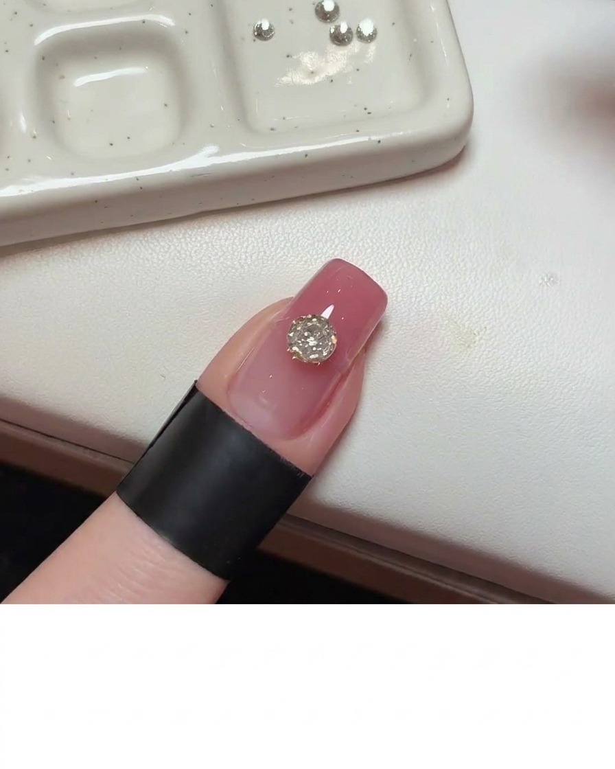 Ein Detailpinsel trägt Klebegel neben dem zentralen Kristall auf.