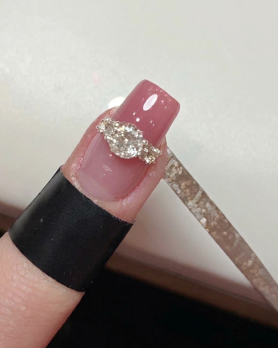 Ein feiner Pinsel zieht Top Coat um die Basis des Kristall-Designs.