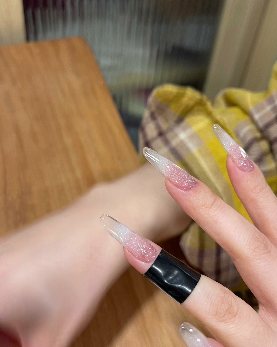 Ein Fingernagel, der unter dem Licht einer UV-/LED-Lampe aushärtet.