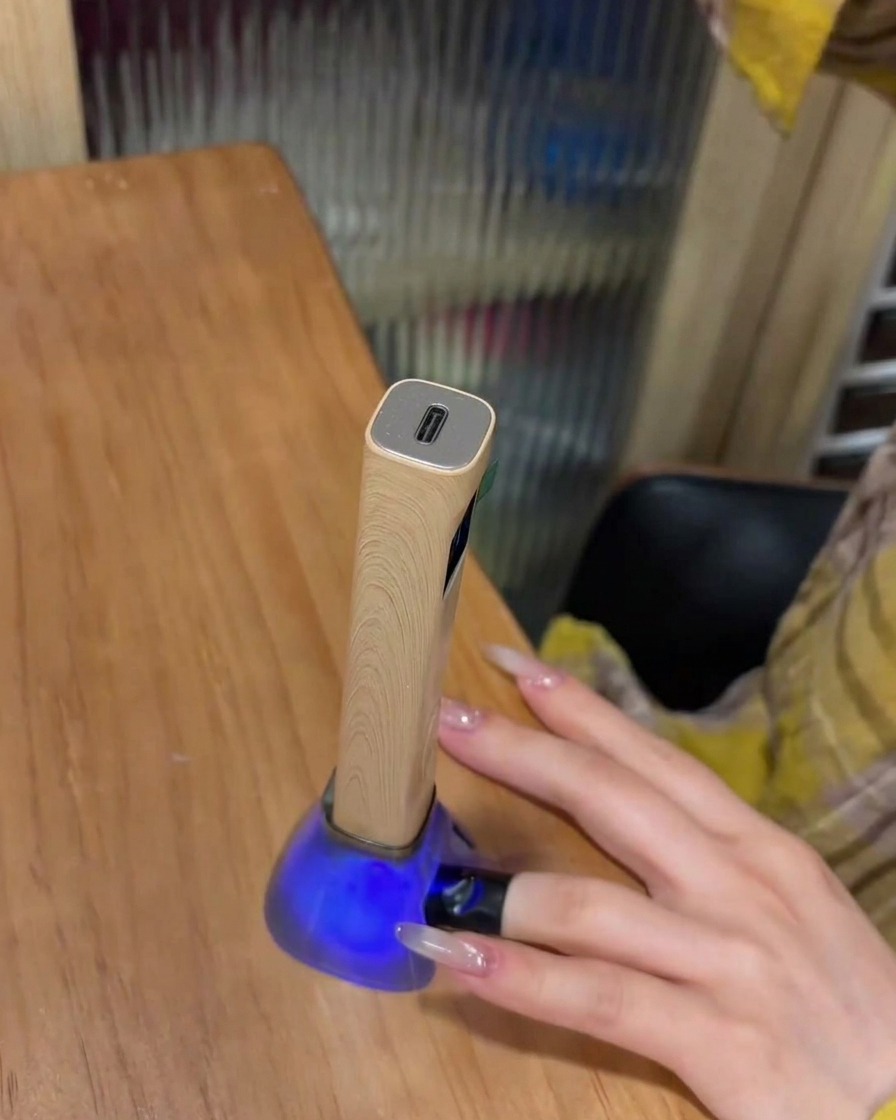 Ein Finger mit platziertem Strass-Charm liegt in einer UV-Lampe zum Aushärten.