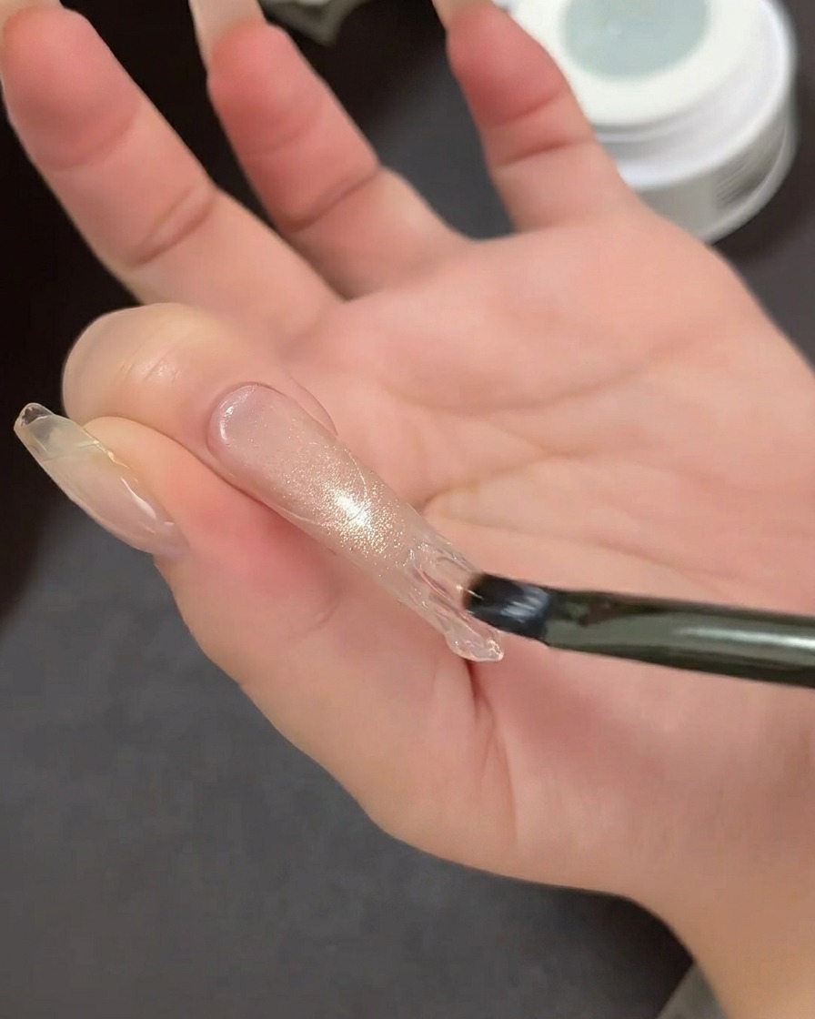 Nahaufnahme eines French-Tip-Führungstickers, der auf einer Nagelverlängerung platziert wird, um den Spitzenbereich zu markieren.