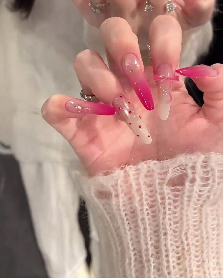 Nahaufnahme einer Hand, die mit einem Pinsel eine nude-farbene Basisschicht auf saubere Nägel aufträgt.