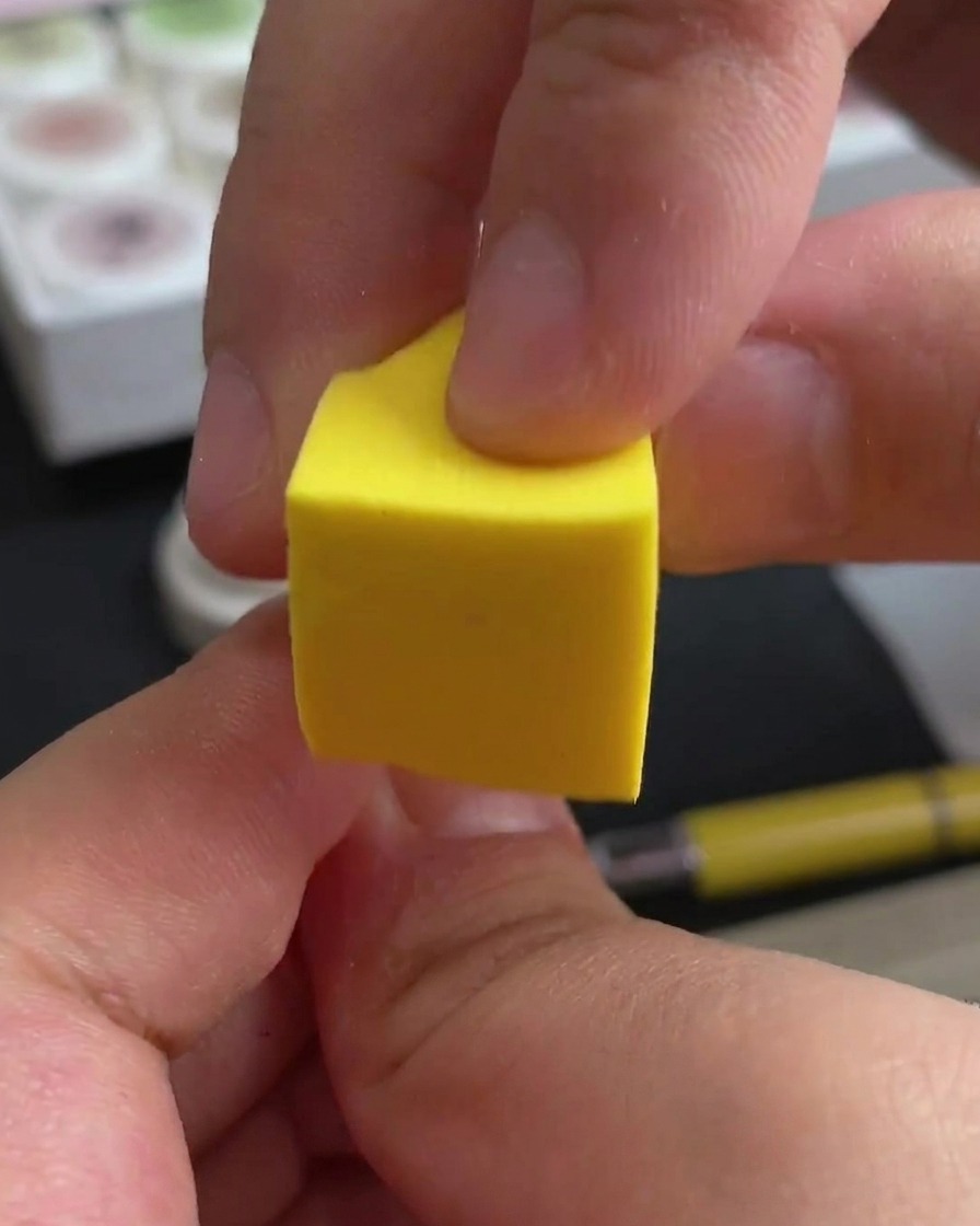 Eine Hand platziert ihre Nägel zur Aushärtung unter eine professionelle UV/LED-Nagellampe.