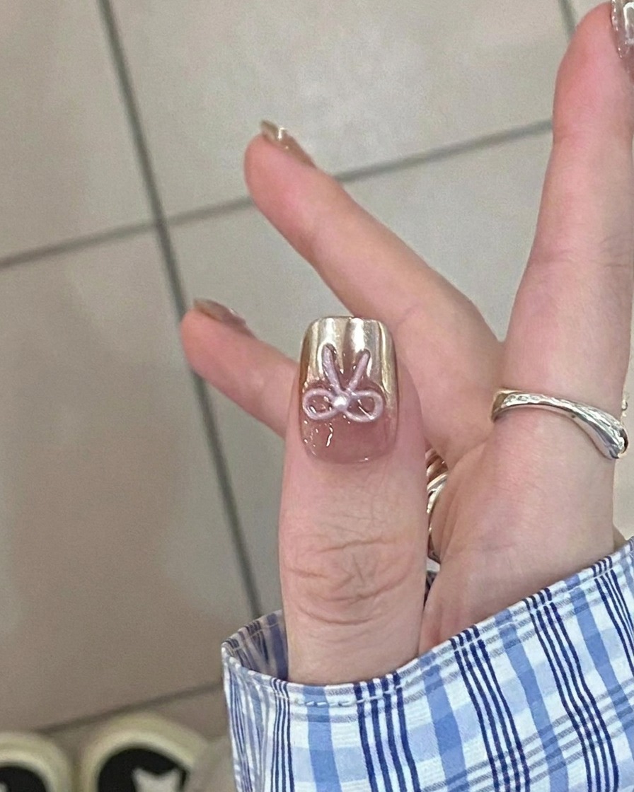 Nahaufnahme eines Pinsels, der einen durchscheinenden Nude-Gel-Base-Coat auf einen sauberen Naturnagel aufträgt.