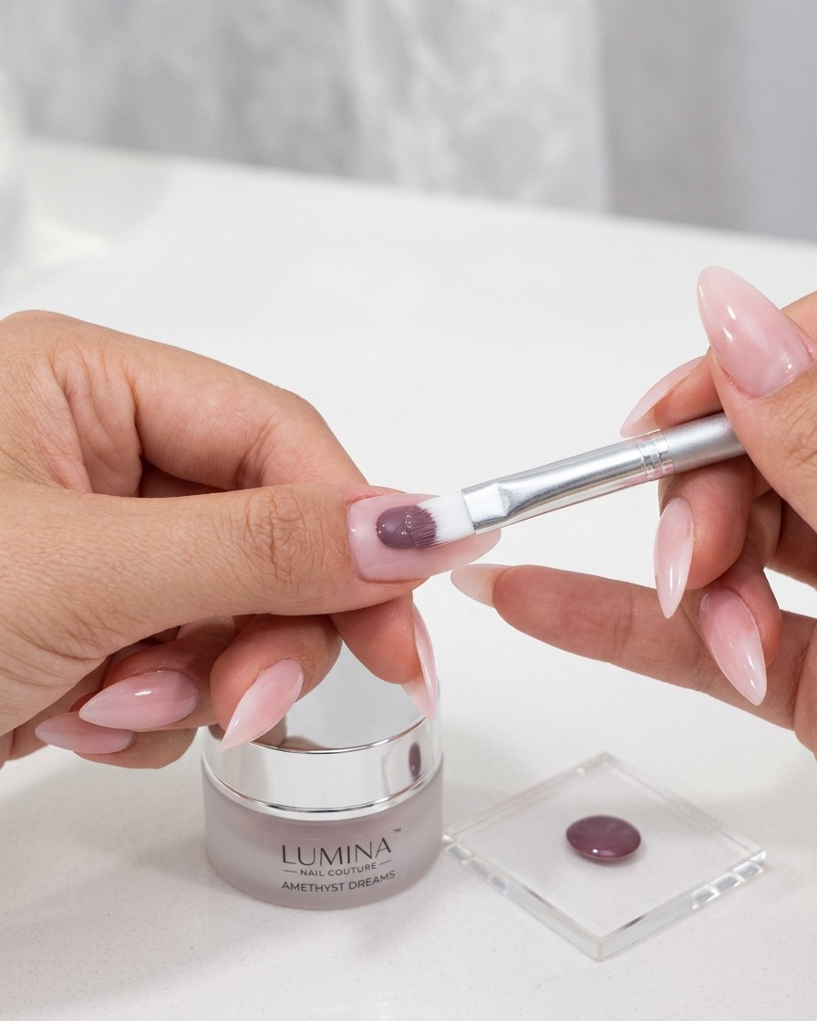 Ein kleiner Pinsel trägt ein farbintensives Cat-Eye-Gel auf die vorbereitete Nageloberfläche auf.