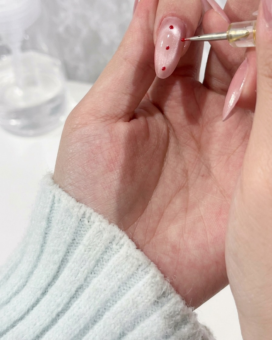 Nahaufnahme, wie ein Detailpinsel einen Tropfen klares Gel auf einen Fingernagel aufträgt.