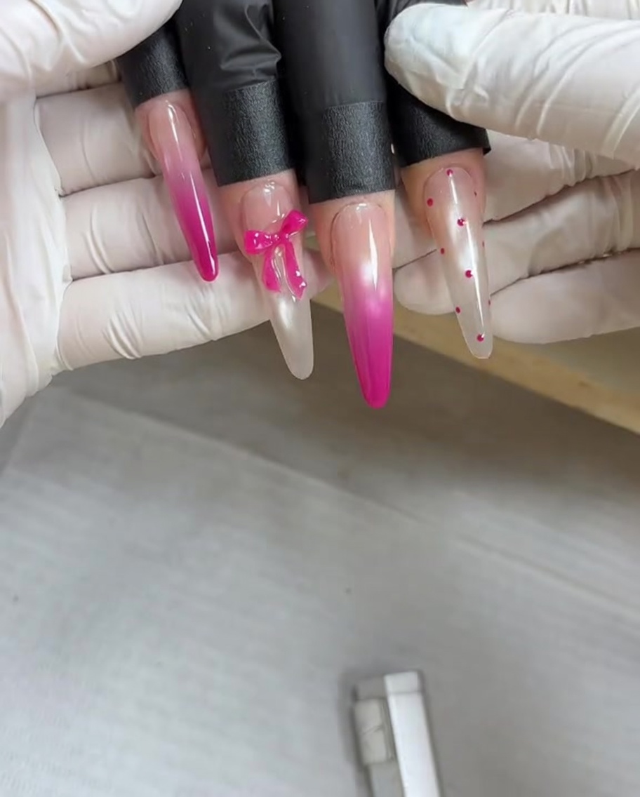 Ein Magnetwerkzeug wird über einen Fingernagel gehalten, der mit feuchtem Metallic-Gel beschichtet ist, um die magnetischen Pigmente in ein Design zu ziehen.