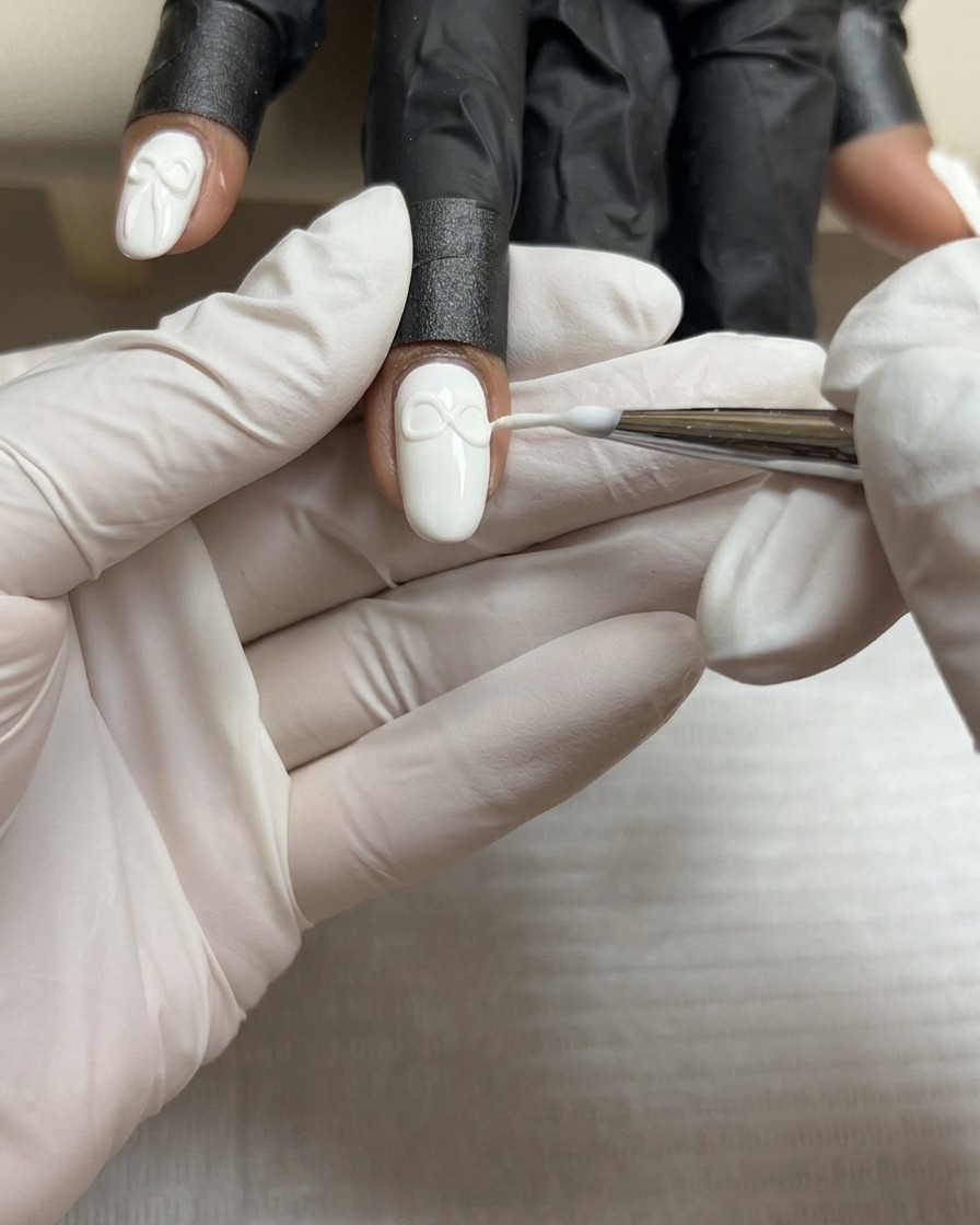 Ein feiner Pinsel formt den zweiten Flügel einer 3D-Gelschleife passend zum ersten.