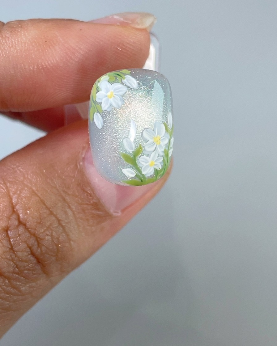 Ein fertig gestalteter Nagel wird zur finalen Aushärtung unter eine UV-Nagellampe gelegt.