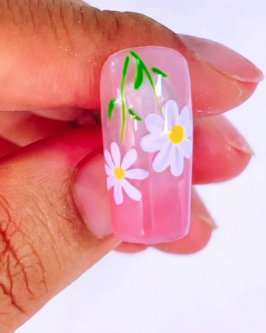 Ein Dotting-Tool trägt einen kleinen gelben Punkt in die Mitte des weißen Gänseblümchens auf.