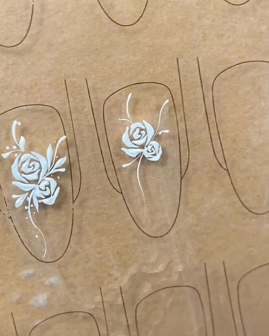 Nahaufnahme der Verfeinerung von Blattformen in einem Nailart-Design, um den Blättern Detail und Fülle zu verleihen.