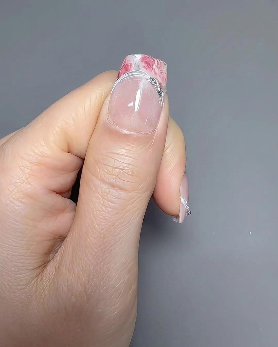 Ein dünner Linierpinsel zieht sorgfältig die Smile-Line an einem French-Nagel nach.