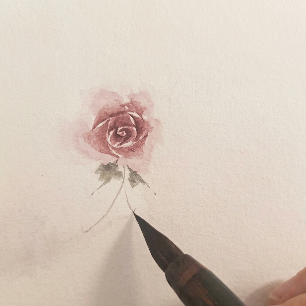 Zwei kleine grüne Aquarellblätter an der Basis einer fertigen Rose.