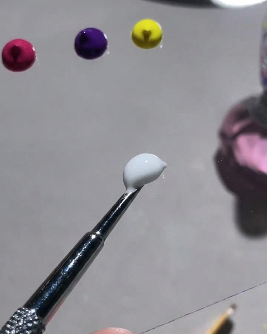 Eine Palette mit verschiedenen Farbpulvern und einem Werkzeug zum Mischen mit weißem Gips-Gel.