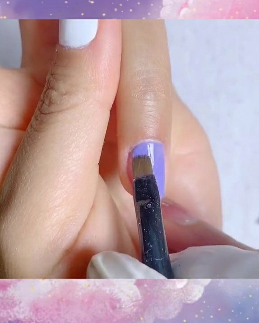Eine detaillierte Nahaufnahme, wie ein Liner-Pinsel eine glatte zweite Schicht leuchtend blau-violetten Gels aufträgt.