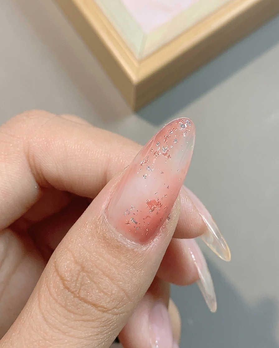 Nahaufnahme des metallischen Schimmers von No. 04 Platin-Silber-Gel auf dem glitzernden rosa Nagel.