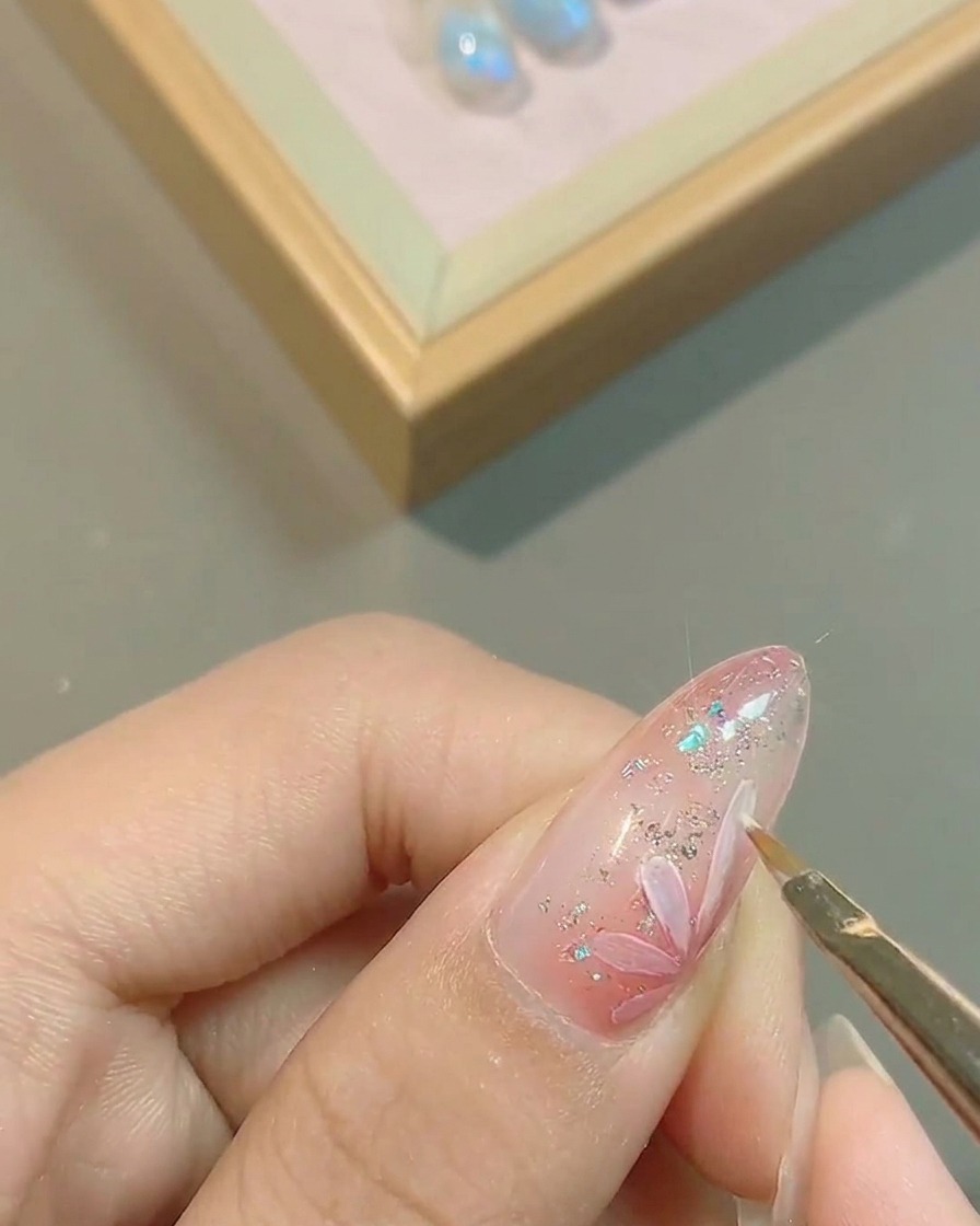 Nahaufnahme der präzisen Nachzeichnung der Blütenränder auf dem rosa Nagel.