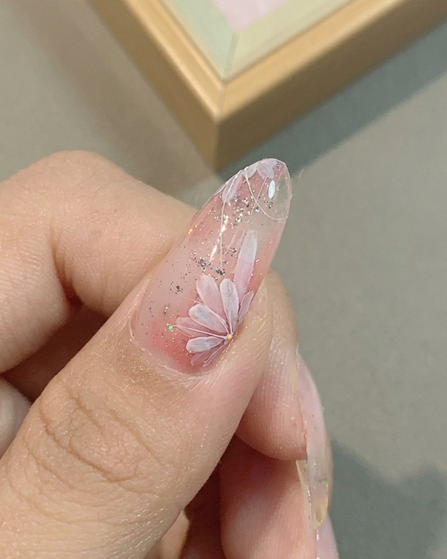 Nahaufnahme der Feinabstimmung der rosa Gänseblümchen-Blütenblätter mit einem Liner-Pinsel.