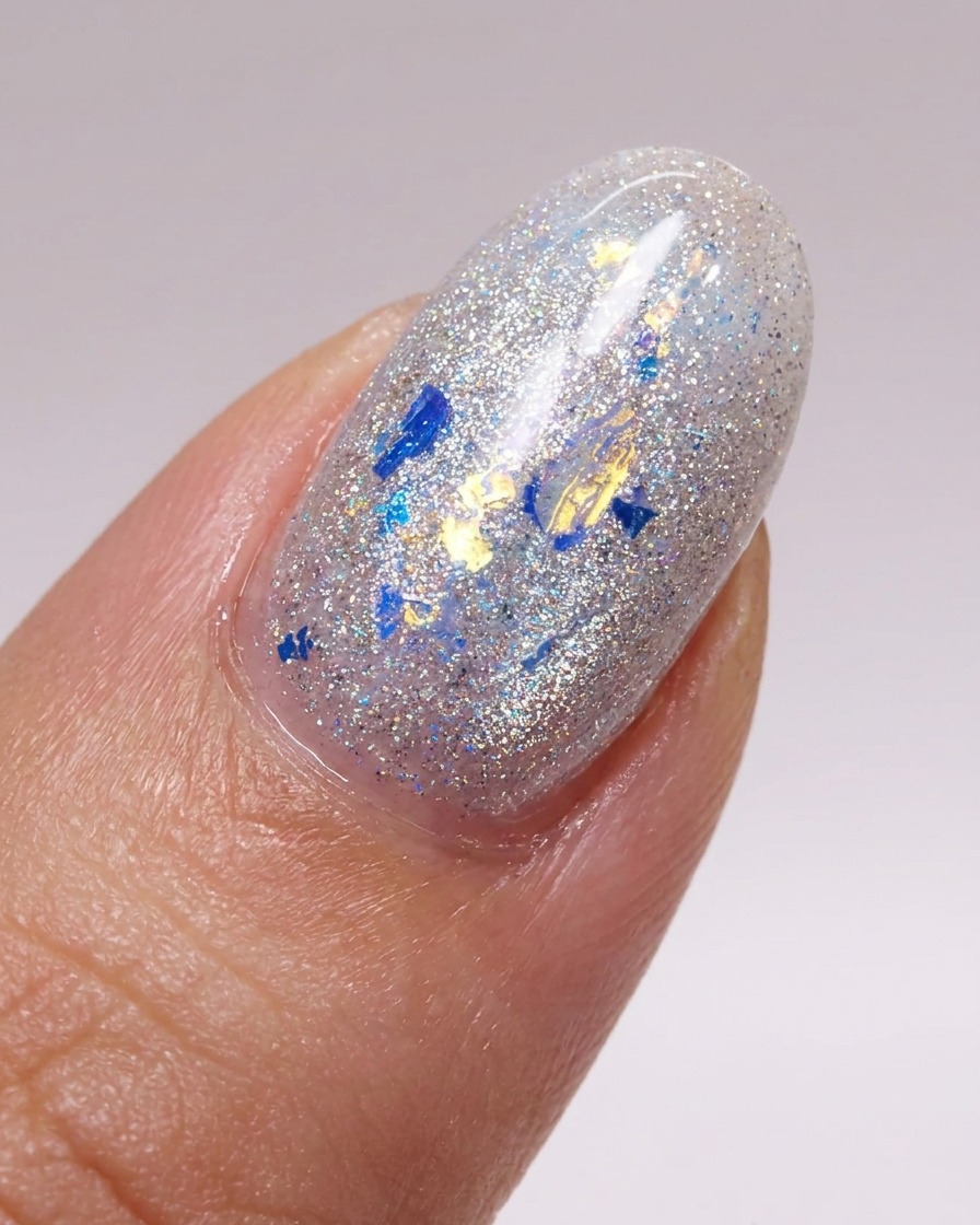 Ein Pinsel trägt eine glänzende Schicht Top Coat über die mit Glitzer verzierten Nägel auf.