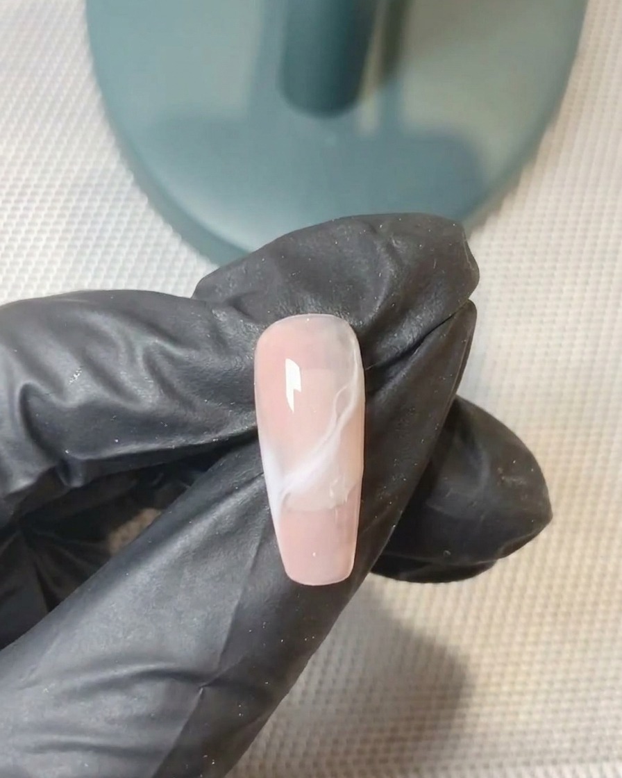 Ein Gel-Pinsel perfektioniert den Verlauf der zweiten Gelschicht auf dem Nagel.