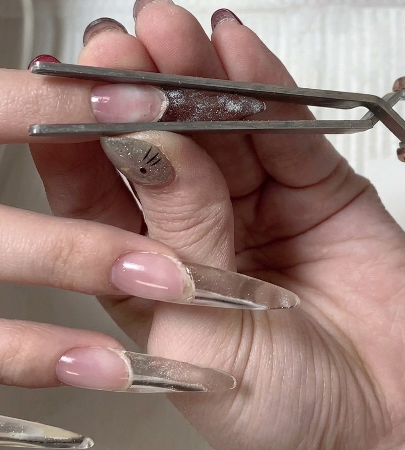 Eine Hand wird so positioniert, dass die Unterseite der Nagelspitze direkt unter der UV/LED-Lampe liegt.