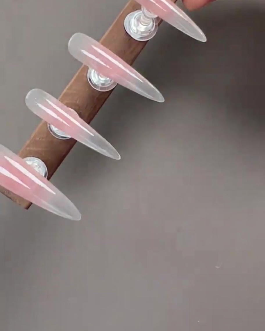 Nägel mit aufgetragenem Cat-Eye-Gel, die den schimmernden magnetischen Effekt zeigen.