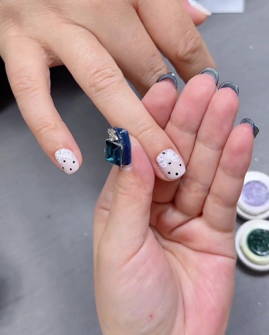 Nahaufnahme eines Nagels mit verfeinerter floraler Rosenkunst und gezielten Freiflächen.