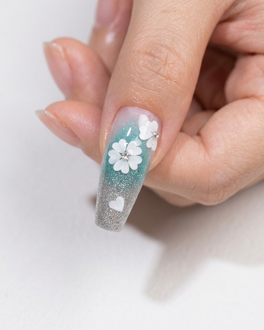 Ein Nagelkunstpinsel trägt eine Schicht klaren, glänzenden Top Coat über ein florales Nageldesign mit eingebetteten Kristallen auf.