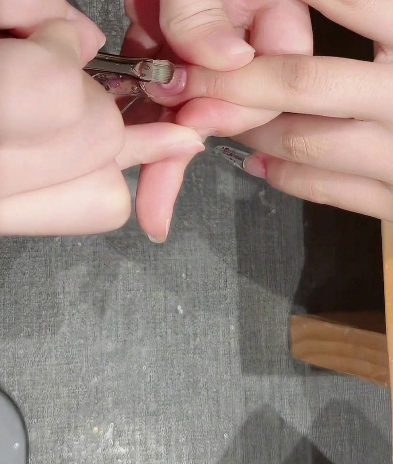 Eine Schicht dickflüssiges Aufbau-Gel wird mit einem Pinsel über den Nagel geglättet.