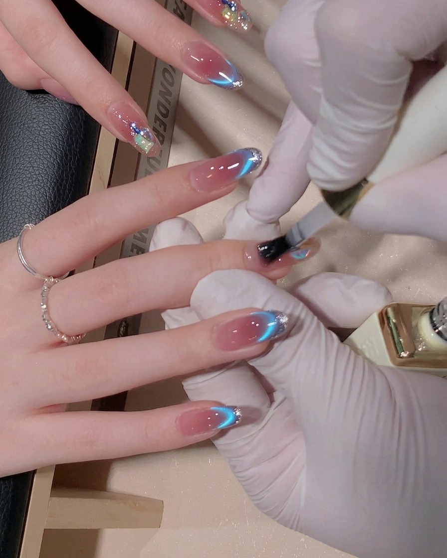 Ein Pinsel trägt eine Schicht glänzendes Top Coat Gel auf einen dekorierten Fingernagel auf, wodurch die Oberfläche feucht und glänzend aussieht.