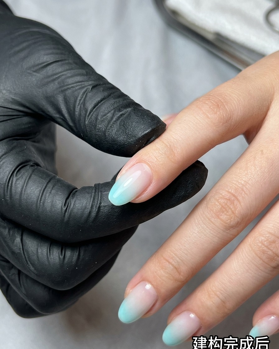Ein Make-up-Schwamm tupft blauen und beigen UV-Lack auf einen Nagel, um einen Ombré-Effekt zu erzielen.