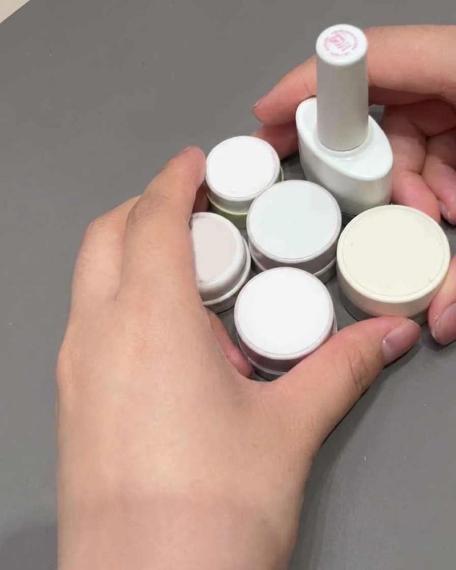 Ein quadratischer Nagelpinsel wird verwendet, um das rosa Gel auf einem French Tip zu glätten und auszufüllen.