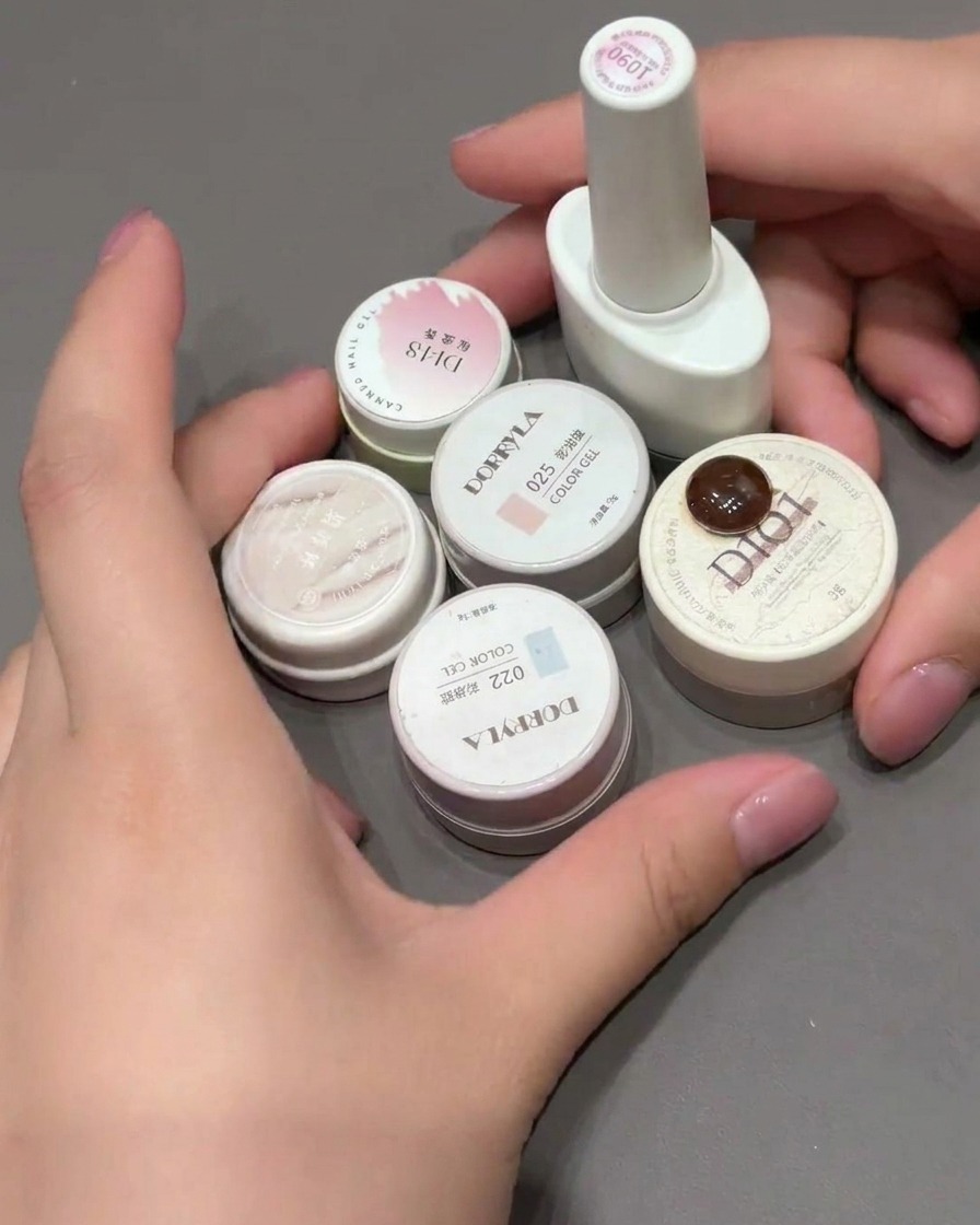 Ein Make-up-Schwamm wird auf eine Nagelspitze getupft, um einen rosa Farbverlauf zu erzeugen.