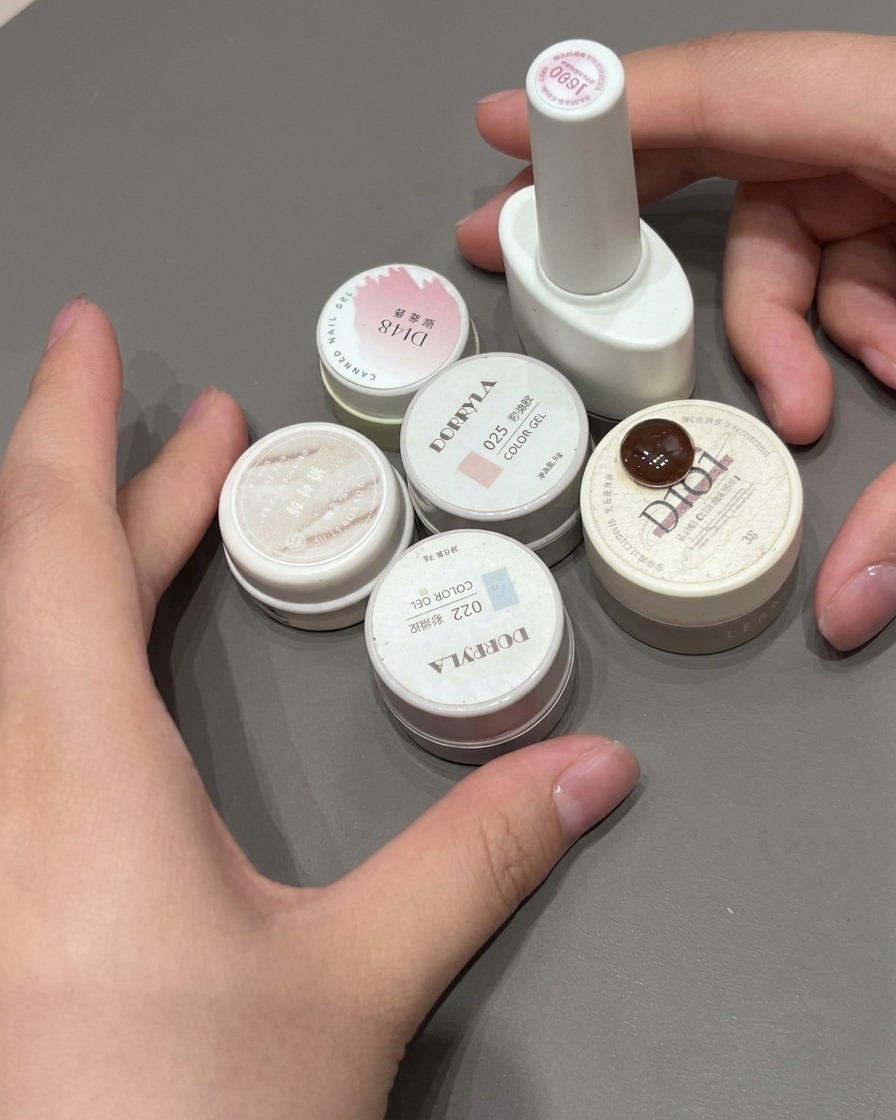 Eine letzte Schicht glänzender Top Coat wird über einen rosa Ombré-French-Nagel aufgetragen.