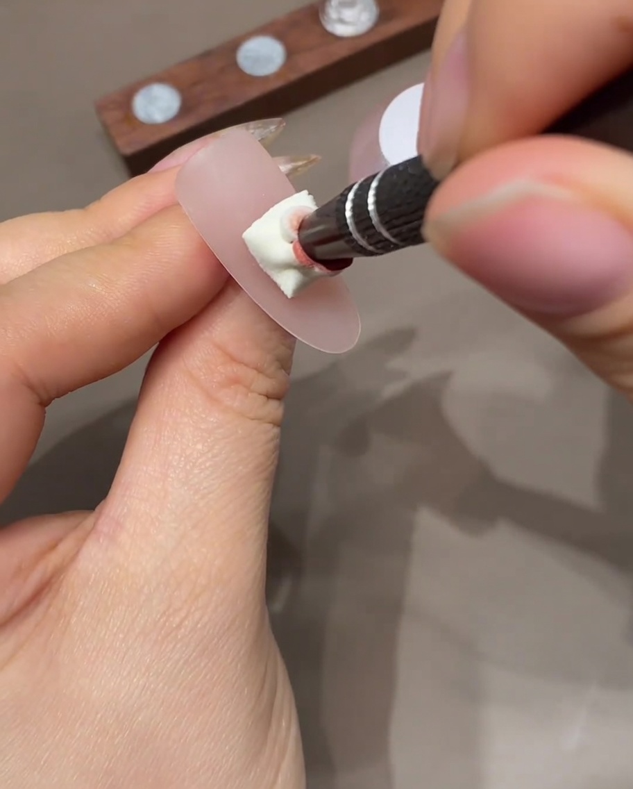 Ein Nagel mit Ombré-Effekt wird unter einer UV-Lampe ausgehärtet.