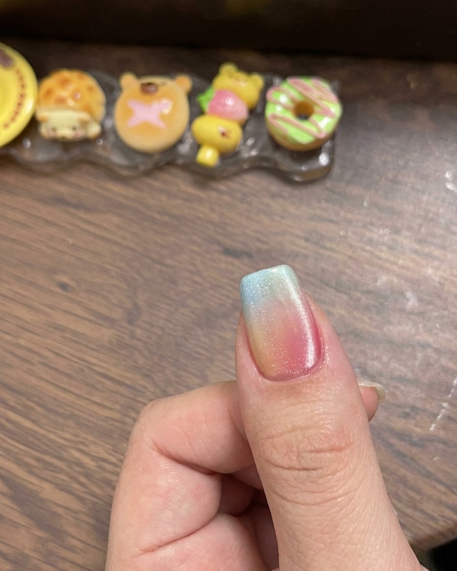 Ein Magnetwerkzeug wird seitlich neben den feuchten Cat-Eye-Nagellack gehalten, um eine scharfe Lichtreflexion zu erzeugen.