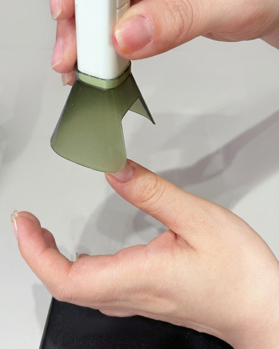 Eine Hand wird unter einer UV-Lampe positioniert, um den Nagel auszuhärten.